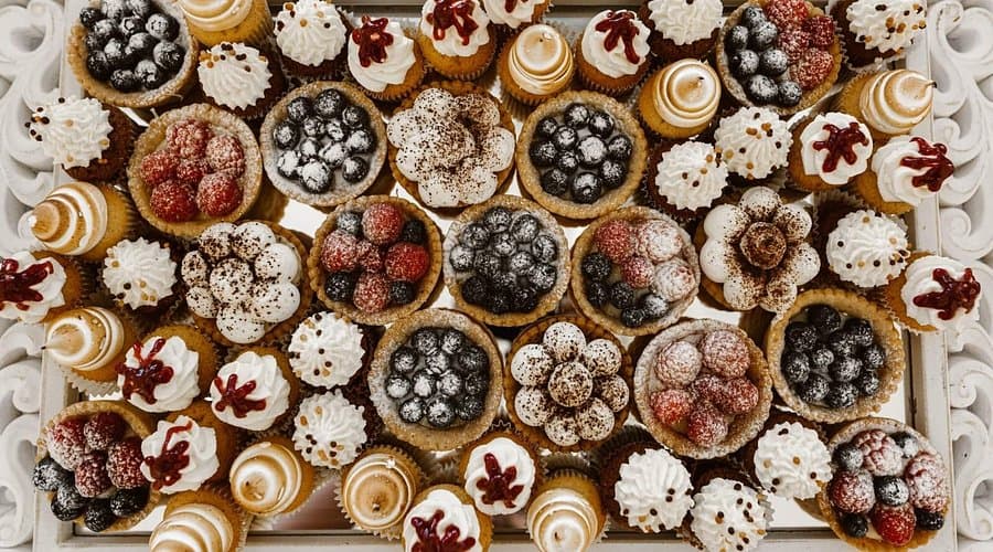 Tarte și cupcakes Konfetti Cakes, aranjate pe o tavă decorativă